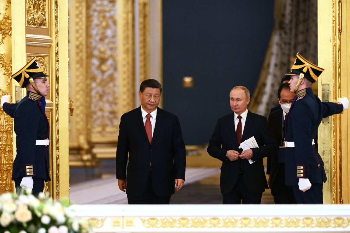 Tổng thống Nga Vladimir Putin và lãnh đạo Trung Quốc Tập Cận Bình bước vào một hội trường trong cuộc họp tại Điện Kremlin ở Moscow hôm 21/03/2023. (Ảnh: Alexey Maishev/Sputnik/AFP qua Getty Images)