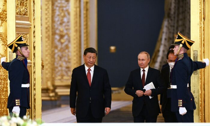 Tổng thống Nga Vladimir Putin và lãnh đạo Trung Quốc Tập Cận Bình bước vào một hội trường trong cuộc hội đàm tại Điện Kremlin ở Moscow hôm 21/03/2023. (Ảnh: Alexey Maishev/ Sputnik/AFP qua Getty Images)