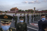 Các công an và nhân viên an ninh kiểm soát đám đông sau một lễ chào cờ chính thức bên cạnh Quảng trường Thiên An Môn và Tử Cấm Thành ở Bắc Kinh, Trung Quốc, vào ngày 01/10/2021. (Ảnh: Kevin Frayer/Getty Images)