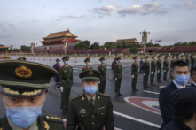 Các công an và nhân viên an ninh kiểm soát đám đông sau một lễ chào cờ chính thức bên cạnh Quảng trường Thiên An Môn và Tử Cấm Thành ở Bắc Kinh, Trung Quốc, vào ngày 01/10/2021. (Ảnh: Kevin Frayer/Getty Images)