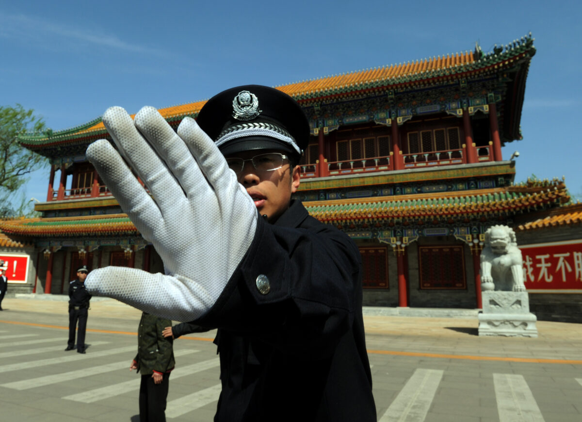 Một cảnh sát Trung Quốc ngăn cản việc chụp hình ở bên ngoài Trung Nam Hải, nơi đặt trụ sở trung ương của Đảng Cộng sản Trung Quốc tại Bắc Kinh vào ngày 11/04/2012. (Ảnh: Mark Ralston/AFP/Getty Images)