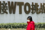 Một cô gái đi ngang qua một bảng quảng cáo khoa trương về tư cách thành viên Tổ chức Thương mại Thế giới (WTO) của Trung Quốc trên đường phố ở Bắc Kinh, vào ngày 19/12/2003. (Ảnh: Goh Chai Hin/AFP/Getty Images)