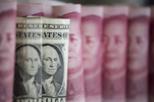 Các tờ tiền 100 nhân dân tệ của Trung Quốc và tờ 1 USD tại Bắc Kinh hôm 06/01/2017. (Ảnh: Fred Dufour/AFP qua Getty Images)