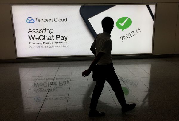 Một người đàn ông đi ngang qua một tấm bảng quảng cáo cho nền tảng truyền thông xã hội WeChat, thuộc sở hữu của Tencent Holdings, tại Phi trường Quốc tế Hồng Kông vào ngày 21/08/2017. (Ảnh: Richard A. Brooks/AFP/Getty Images)