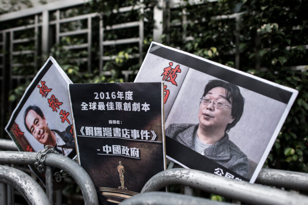 Các tấm bích chương in hình người bán sách bị mất tích Quế Mẫn Hải (Gui Minhai, phải) do các thành viên của Đảng Công Dân để lại bên ngoài văn phòng liên lạc Trung Quốc ở Hồng Kông, ngày 19/01/2016. (Ảnh: Philippe Lopez/AFP qua Getty Images)