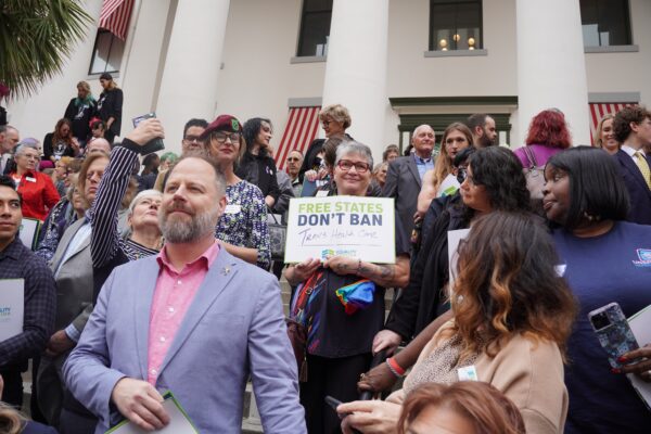 Một người biểu tình tại cuộc tập hợp Bình Đẳng ở Florida tại Tòa nhà Quốc hội ở Tallahassee, Florida, hôm 13/03/2023, giơ một tấm biểu ngữ có nội dung “Các Tiểu bang Tự do Không cấm Dịch vụ Chăm sóc Sức khỏe cho Người chuyển giới.” (Ảnh: Dan M. Berger/The Epoch Times)