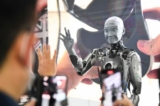 Những người tham dự chụp ảnh và nói chuyện với robot hình người Engineered Arts Ameca có trí tuệ nhân tạo, khi robot này được trình diễn tại Triển lãm Điện tử Tiêu dùng (CES) ở Las Vegas, Nevada vào ngày 05/01/2022. (Ảnh: Patrick T. Fallon/AFP qua Getty Images)