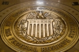 Con dấu của Hội đồng Thống đốc Hệ thống Dự trữ Liên bang Hoa Kỳ được trưng bày tại nền Tòa nhà Hội đồng Dự trữ Liên bang Marriner S. Eccles ở Hoa Thịnh Đốn. (Ảnh: Andrew Harnik/AP)