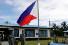 Các binh sĩ Philippines đứng trước một lá quốc kỳ Philippines tại đảo Thị Tứ (Thitu Island) ở vùng Biển Đông đang tranh chấp vào ngày 21/04/2017. (Ảnh: Erik De Castro/Reuters)