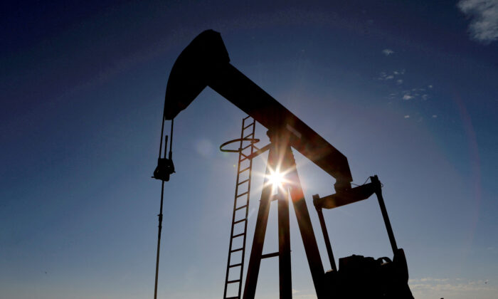 Mặt trời phía sau một máy bơm dầu thô ở lưu vực Permian ở Loving County, Texas hôm 22/11/2019. (Ảnh: Angus Mordant/Reuters)