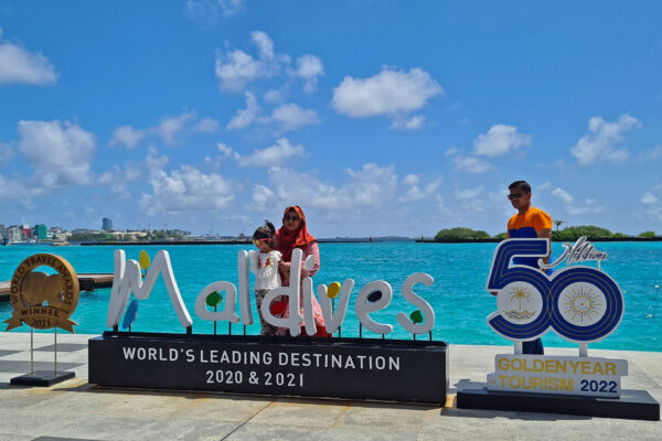 Du khách tạo dáng chụp ảnh tại Phi trường Quốc tế Velana ở Maldives hôm 14/07/2022. (Ảnh: AFP qua Getty Images)