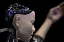 Một robot AI có tên “Alter 3: Offloaded Agency” được chụp trong một cuốn sách quảng cáo để quảng bá cho cuộc triển lãm sắp tới có tên “AI: More than Human” (AI: Hơn cả Con người), tại Trung tâm Barbican ở London vào ngày 15/05/2019. (Ảnh: Ben Stansall/AFP qua Getty Hình ảnh)