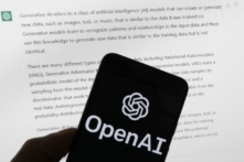 Logo OpenAI trên một chiếc điện thoại di động phía trước màn hình máy điện toán hiển thị câu trả lời từ ChatGPT ở Boston hôm 21/03/2023. (Ảnh: Michael Dwyer/AP Photo)