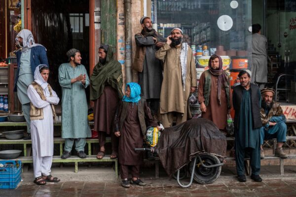 Người dân trú mưa bên ngoài một cửa hàng ở Kabul hôm 23/03/2023. (Ảnh: Wakil Kohsar/AFP qua Getty Images)