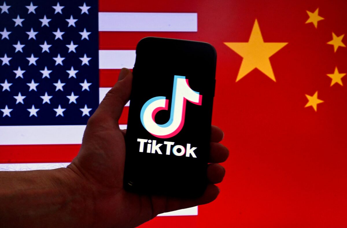 Logo ứng dụng mạng xã hội TikTok được hiển thị trên màn hình iPhone trước nền cờ Hoa Kỳ và cờ Trung Quốc ở thủ đô Hoa Thịnh Đốn, hôm 16/03/2023. (Ảnh: Olivier Douliery/AFP qua Getty Images)