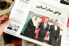 Một người cầm tờ báo địa phương đưa tin về thỏa thuận khôi phục quan hệ giữa Iran và Saudi Arabia do Trung Quốc làm trung gian, tại thủ đô Tehran của Iran hôm 11/03/2023. (Ảnh: Atta Kenare/AFP qua Getty Images)