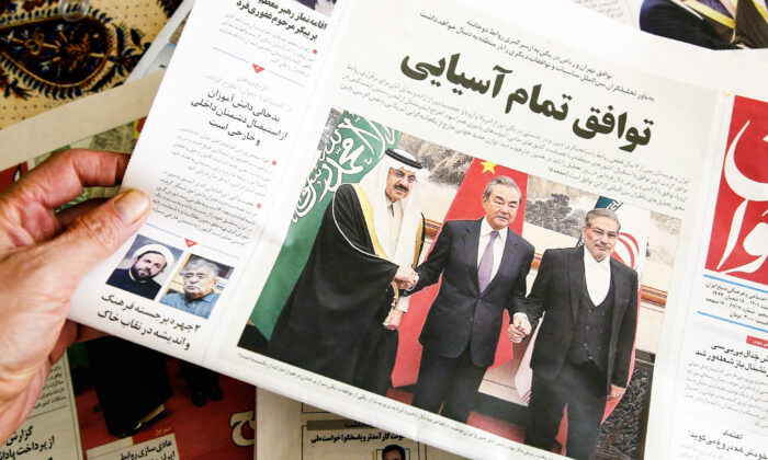 Một người đàn ông cầm một tờ báo địa phương đưa tin về thỏa thuận bình thường hóa bang giao giữa Iran và Saudi Arabia do Trung Quốc làm trung gian, tại thủ đô Tehran của Iran hôm 11/03/2023. (Ảnh: Atta Kenare/AFP qua Getty Images)
