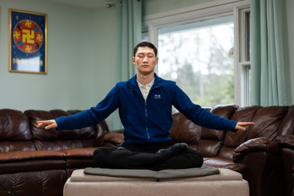 Anh Vương Toàn, nghệ sĩ múa chính của đoàn nghệ thuật biểu diễn Shen Yun, luyện bài tĩnh công của Pháp Luân Công tại nhà của mình ở tiểu bang New York hôm 31/03/2023. (Anh: Samira Bouaou/The Epoch Times)
