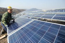 Một công nhân đang lắp đặt các tấm pin mặt trời silicon đa tinh thể khi một dự án  quang năng trên mặt đất, khởi công ở thị trấn Quan Thủy thuộc quận Mưu Bình vào ngày 17/11/2015, ở Yên Đài, tỉnh Sơn Đông, Trung Quốc. (Ảnh: VCG/VCG/Getty Images)