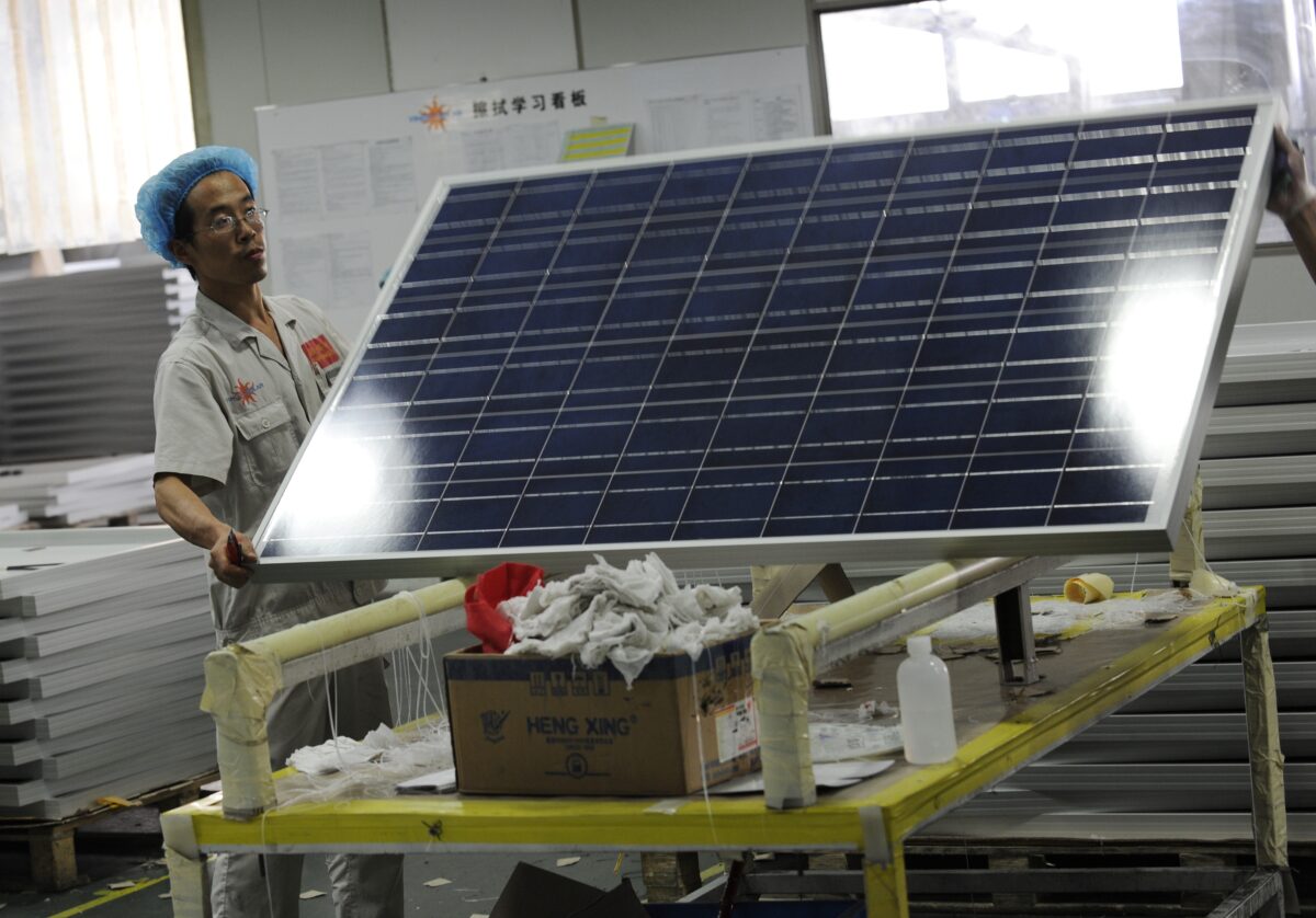 Một công nhân nâng một tấm pin quang năng tại nhà máy Yingli Solar, một công ty hàng đầu về quang năng và là một trong những nhà sản xuất tấm quang năng lớn nhất thế giới ở Bảo Định, tỉnh Hà Bắc, hôm 30/09/2010. (Ảnh: PeterR Parks/AFP/Getty Images)