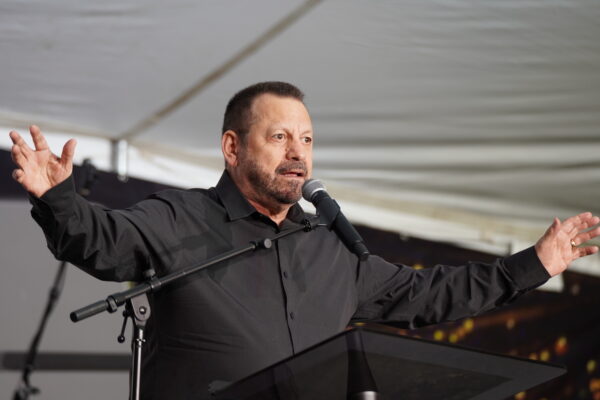 Mục sư Mario Murillo sống tại Tennessee, giơ cao hai cánh tay trong một bài thuyết giảng tại lều ở Bakersfield, California, hôm 12/03/2023. (Ảnh: Allan Stein/The Epoch Times)