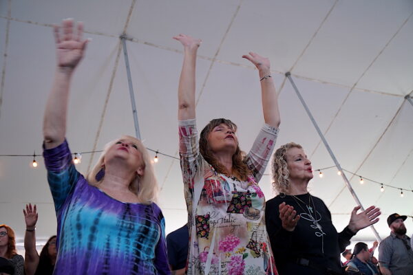 Ba người phụ nữ giơ cao cánh tay cầu nguyện trong một buổi lễ ở Bakersfield, California, hôm 12/03/2023. (Ảnh: Allan Stein/The Epoch Times)