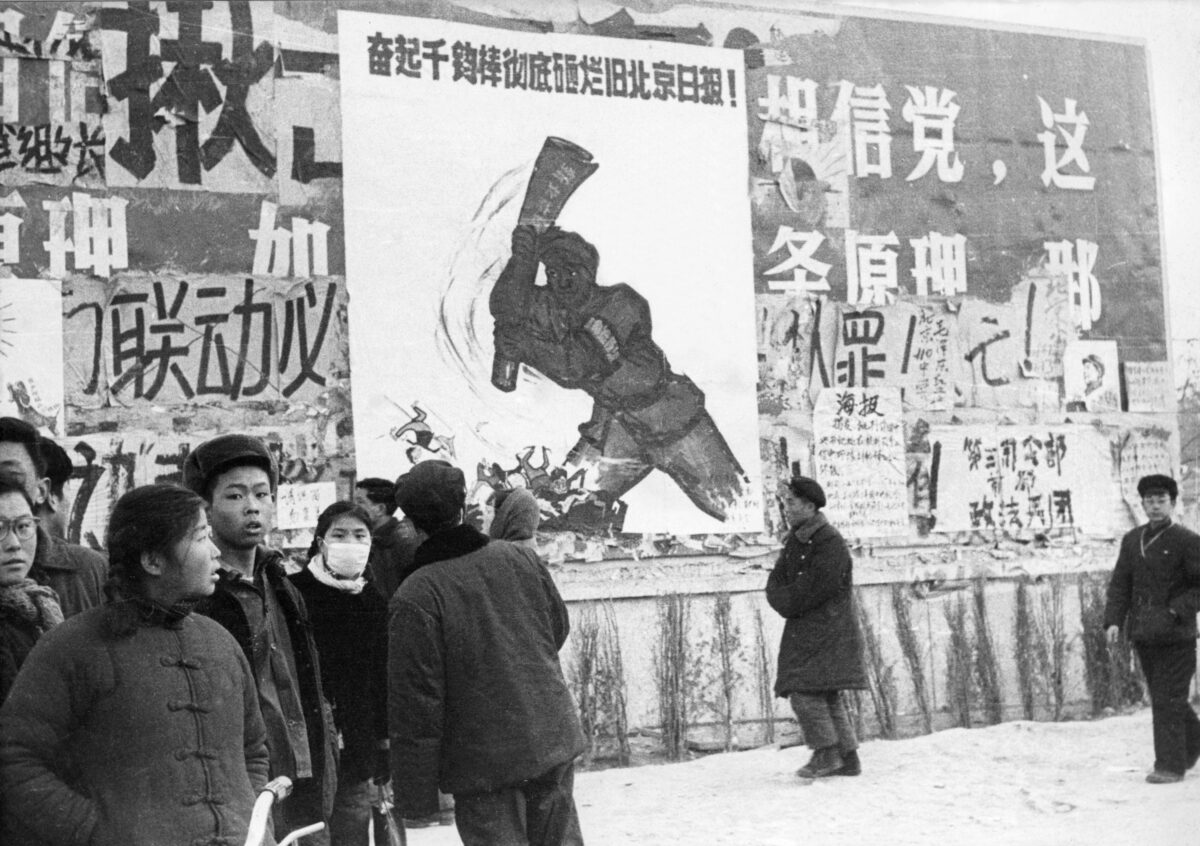 Một nhóm nhỏ thanh niên Trung Quốc đi ngang qua một số đại tự báo (bích chương vẽ bằng tay), những tranh cổ động cách mạng, hồi tháng 02/1967 tại trung tâm thành phố Bắc Kinh trong cuộc “Đại Cách mạng Văn hóa Vô sản.” Kể từ khi Cách mạng Văn hóa được phát động hồi tháng 05/1966 tại Đại học Bắc Kinh, ông Mao Trạch Đông đã nhắm đến việc giành lại quyền lực sau thất bại của “Đại Nhảy Vọt”. (Ảnh: Vincent/AFP qua Getty Images)