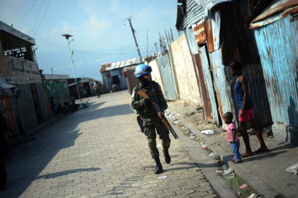 Một thành viên của Phái bộ Ổn định Liên Hiệp Quốc tại Haiti tuần tra trong khu ổ chuột Cite Soleil của thành phố Port-au-Prince vào ngày 11/03/2014. (Ảnh: Hector Retamal/AFP qua Getty Images)