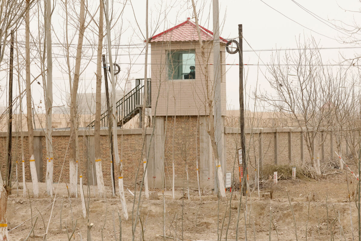 Một nhân viên an ninh quan sát từ một tháp canh xung quanh một cơ sở giam giữ ở Huyện Sa Xa, Khu tự trị Duy Ngô Nhĩ Tân Cương, Tây Bắc Trung Quốc vào ngày 21/03/2021. (Ảnh: Ng Han Guan/AP Photo)