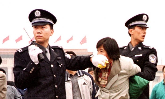 ác công an Trung Quốc bắt giữ một học viên Pháp Luân Công tại Quảng trường Thiên An Môn ở Bắc Kinh vào ngày 10/01/2000. (Ảnh: Chien-Min Chung/AP Photo)
