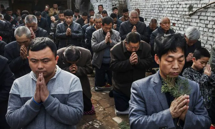 Các tín đồ Công Giáo Trung Quốc quỳ gối và cầu nguyện trong Thánh lễ Chúa Nhật Lễ Lá trong Tuần Lễ Phục sinh tại một nhà thờ dưới lòng đất hôm 09/04/2017. (Ảnh: Kevin Frayer/Getty Images)