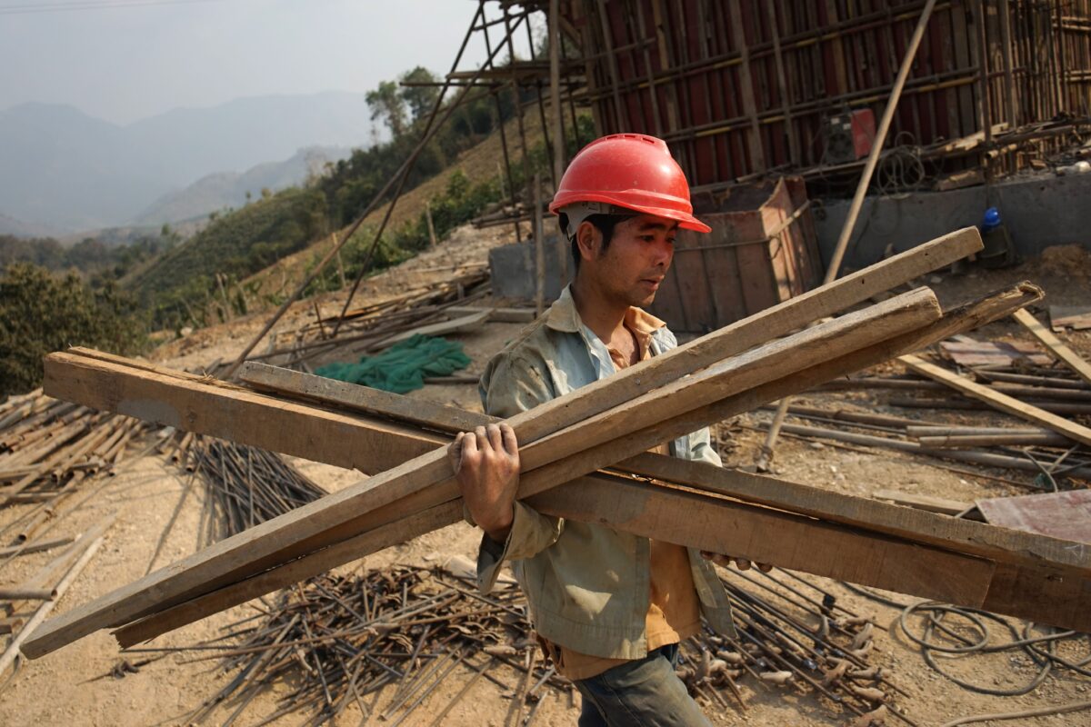 Một công nhân Trung Quốc mang vật liệu cho tuyến đường sắt đầu tiên nối Trung Quốc với Lào, một phần quan trọng trong dự án “Vành đai và Con đường” của Bắc Kinh bắc qua sông Mekong ở Luang Prabang, Lào, vào ngày 08/02/2020. (Ảnh: Aidan Jones/AFP qua Getty Images)