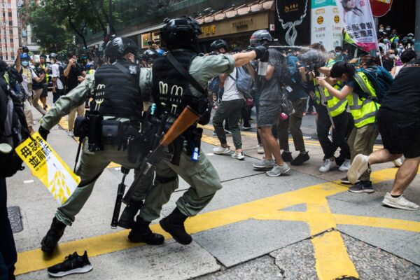Cảnh sát chống bạo động xịt hơi cay về phía các ký giả vào dịp kỷ niệm 23 năm Hồng Kông được Anh giao lại cho Trung Quốc khi những người biểu tình tập hợp trong một cuộc biểu tình phản đối Luật An ninh Quốc gia mới ở Hồng Kông vào ngày 01/07/2020. (Ảnh: Dale De La Rey/AFP qua Getty Images)
