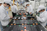 Các công nhân nhà máy tại Công ty TNHH Pin Xe Điện Hân Vượng Đạt (Xinwangda), nơi sản xuất pin lithium cho xe hơi điện và các mục đích sử dụng khác, ở Nam Kinh thuộc tỉnh Giang Tô phía đông Trung Quốc, vào ngày 12/03/2021. (Ảnh: STR/AFP qua Getty Images)