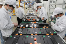 Các công nhân nhà máy tại Công ty TNHH Pin Xe Điện Hân Vượng Đạt (Xinwangda), nơi sản xuất pin lithium cho xe hơi điện và các mục đích sử dụng khác, ở Nam Kinh thuộc tỉnh Giang Tô phía đông Trung Quốc, vào ngày 12/03/2021. (Ảnh: STR/AFP qua Getty Images)