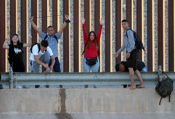 Những người xin tị nạn từ Venezuela ra hiệu khi họ đến hàng rào biên giới Hoa Kỳ để tự nộp mình cho Lực lượng Tuần tra Biên giới Hoa Kỳ sau khi băng qua sông Rio Grande từ Mexico ở El Paso, Texas, vào ngày 22/09/2022. (Ảnh: Joe Raedle/Getty Images)
