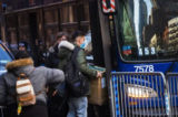 Những người nhập cư bất hợp pháp mang đồ đạc của họ lên một chiếc xe buýt sau khi đồng ý di dời sau khi bị trục xuất khỏi khách sạn Watson ở thành phố New York hôm 30/01/2023. (Ảnh: Michael M. Santiago/Getty Images)