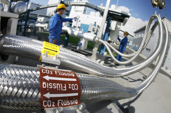 Hai nhân viên làm việc trên các đường ống dẫn khí CO2 lỏng tại nhà máy điện “Schwarze Pumpe” (“Bơm Đen”) Vattenfall ở Werder, Đức vào ngày 08/09/2008. Nhà máy điện này đang sử dụng công nghệ Thu hồi và Lưu trữ Carbon, hay CCS, để thu giữ các khí nhà kính được tạo ra khi đốt cháy nhiên liệu hóa thạch. (Ảnh: Michael Urban/ DDP/AFP qua Getty Images)