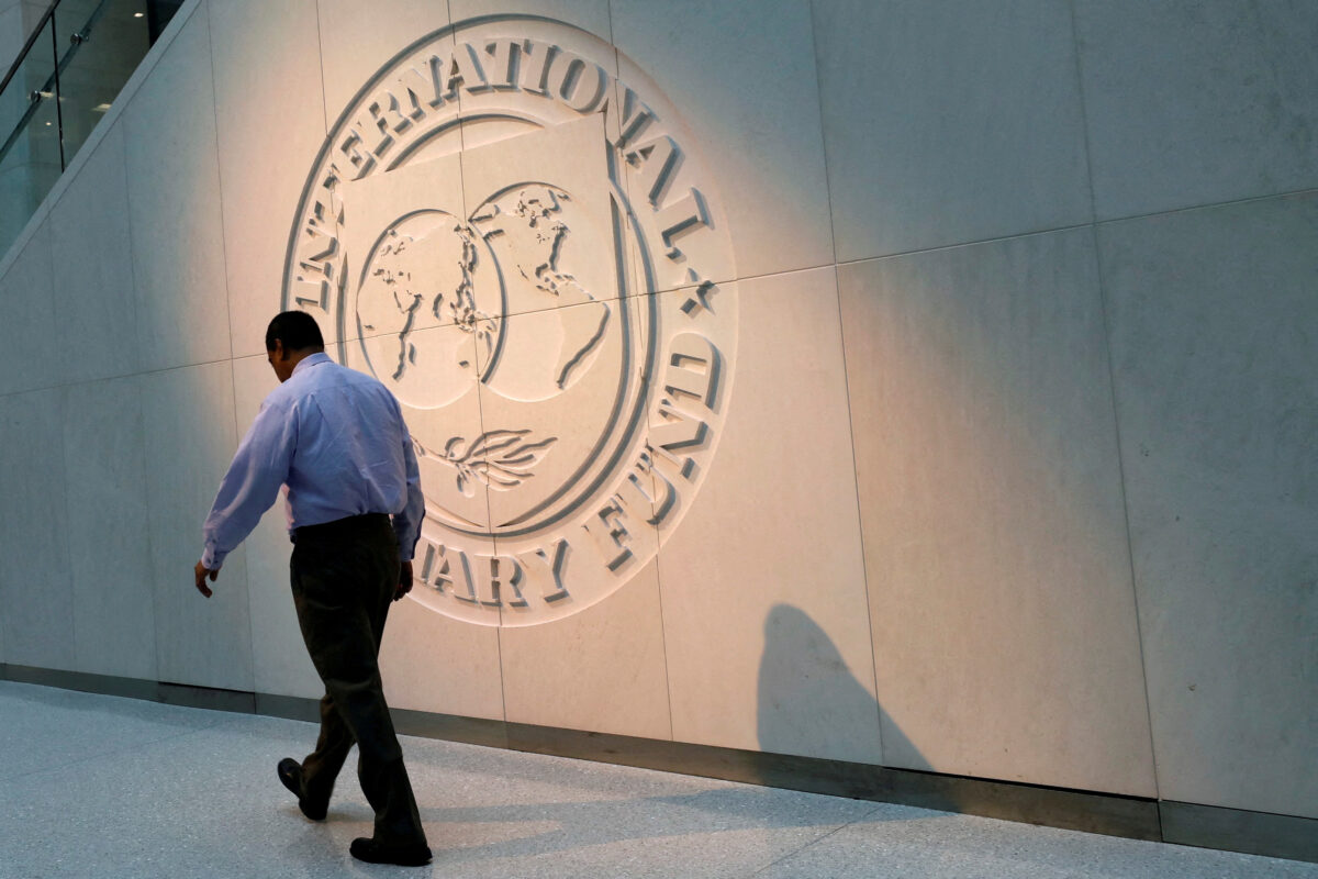 Một khách bộ hành đi ngang qua logo của Quỹ Tiền tệ Quốc tế (IMF) tại trụ sở chính ở Hoa Thịnh Đốn, vào ngày 10/05/2018. (Ảnh: Yuri Gripas/Reuters)