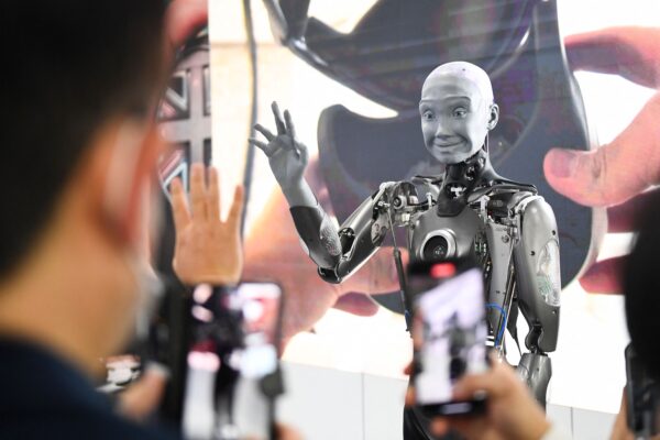 Những người tham dự chụp ảnh và giao tiếp với robot hình người Engineered Arts Ameca có trí thông minh nhân tạo khi robot này được trưng bày trong Triển lãm Điện tử Tiêu dùng (CES) ở Las Vegas, Nevada, hôm 05/01/2022. (Ảnh: Patrick T. Fallon/AFP qua Getty Images )
