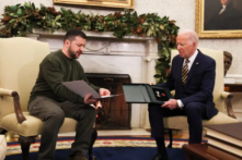 Tổng thống Ukraine Volodymyr Zelensky (bên trái) trao món quà của một quân nhân cho Tổng thống Hoa Kỳ Joe Biden tại Oval Office ở Tòa Bạch Ốc vào ngày 21/12/2022. (Ảnh: Leah Millis/Reuters)