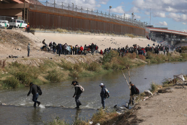 Mọi người đi bộ qua Rio Grande để trình diện các nhân viên Tuần tra Biên giới Hoa Kỳ ở El Paso, Texas, nhìn từ Ciudad Juarez, Mexico, vào ngày 13/12/2022. (Ảnh: Herika Martinez/AFP/Getty Images)