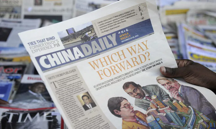 Một người mua báo đang đọc ấn bản Phi Châu của tờ Nhật báo Trung Quốc trước một quầy báo ở thủ đô Kenya trong bức ảnh tư liệu đề ngày ngày 14/12/2012 này. (Ảnh: Tony Karumba/AFP qua Getty Images)