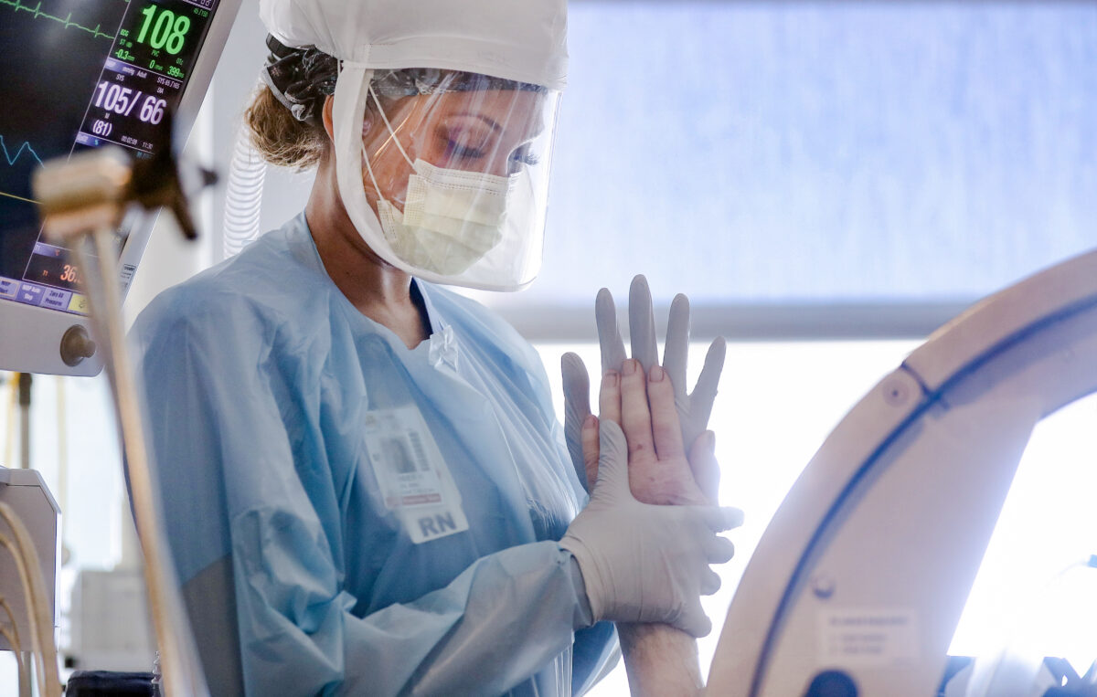 Y tá Amber Kirk đeo thiết bị bảo hộ cá nhân khi cô thực hiện một loạt bài tập vận động cho một bệnh nhân COVID-19 trong phòng chăm sóc đặc biệt tại Bệnh viện Sharp Grossmont giữa đại dịch virus corona ở La Mesa, California, vào ngày 05/05/2020. (Ảnh: Mario Tama/ Getty Images)