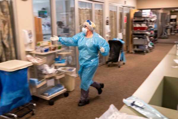 Một y tá tại Trung tâm Y tế Three Rivers Asante chạy đến một căn phòng trong Đơn vị Chăm sóc Đặc biệt để giúp nhân viên y tế điều trị cho một bệnh nhân COVID-19 ở Grants Pass, Oregon, vào ngày 09/09/2021. (Ảnh: Nathan Howard/Getty Images)