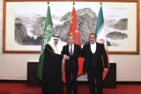 Ông Ali Shamkhani, thư ký của Hội đồng An ninh Quốc gia Tối cao Iran (phải) bắt tay với cố vấn an ninh quốc gia của Saudi Arabia, ông Musaad bin Mohammed al-Aiban (trái), khi ông Vương Nghị, nhà ngoại giao cao cấp nhất của Trung Quốc, chứng kiến. (Ảnh: Luo Xiaoguang/AP Photo)
