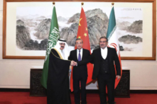Ông Ali Shamkhani, thư ký của Hội đồng An ninh Quốc gia Tối cao Iran (phải) bắt tay với cố vấn an ninh quốc gia của Saudi Arabia, ông Musaad bin Mohammed al-Aiban (trái), khi ông Vương Nghị, nhà ngoại giao cao cấp nhất của Trung Quốc, chứng kiến. (Ảnh: Luo Xiaoguang/AP Photo)