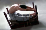 Một cảnh tái hiện phương pháp tra tấn “ghế cọp”: Một học viên Pháp Luân Công bị trói vào một chiếc bàn lộn ngược ở một tư thế có thể gây đau đớn không thể chịu nổi và khiến nạn nhân bất tỉnh. (Ảnh: Minghui.org)