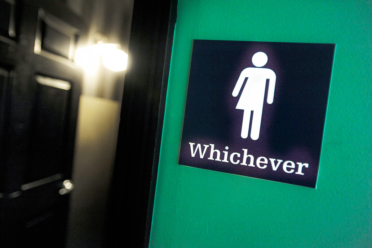 Một biển báo trung lập về giới tính được dán bên ngoài một nhà vệ sinh tại Oval Park Grill ở Durham, North Carolina, vào ngày 11/05/2016. (Ảnh: Sara D. Davis/Getty Images)