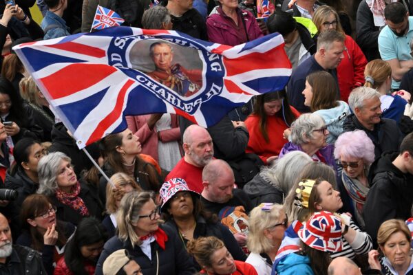 Những người chúc mừng xếp hàng trên tuyến đường mà Lễ rước của Đức vua đi qua, đoạn đường dài hai kilometre từ Cung điện Buckingham đến Tu viện Westminster, ở trung tâm London, hôm 06/05/2023. (Ảnh: Sebastien Bozon/pool qua Reuters)